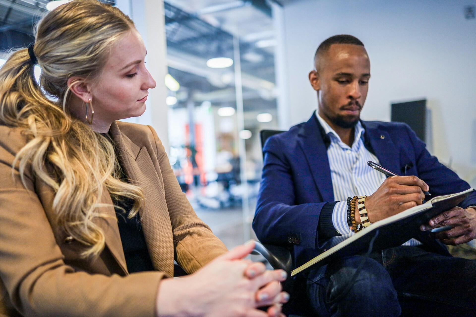 Meeting A woman looks at her colleague's notes during a business meeting