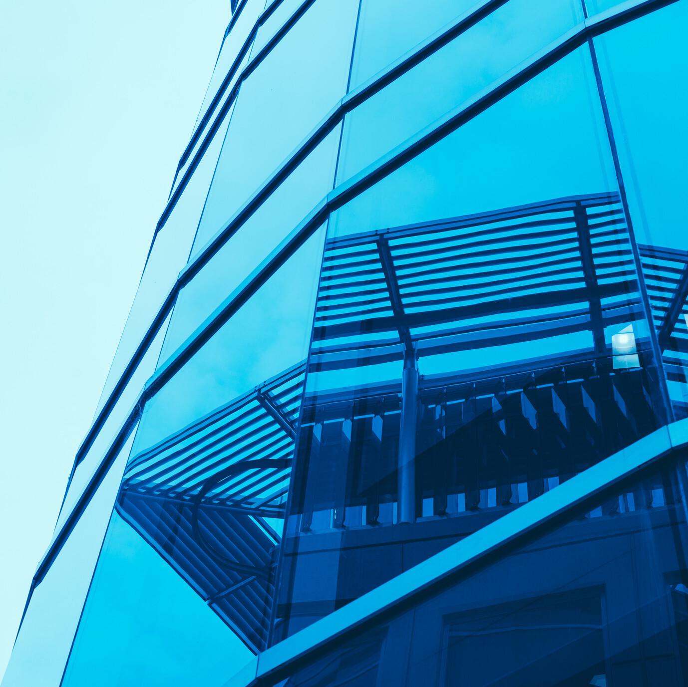 Spiegelung Häuser An einem verglasten Gebäude spiegeln sich weitere Häuser.