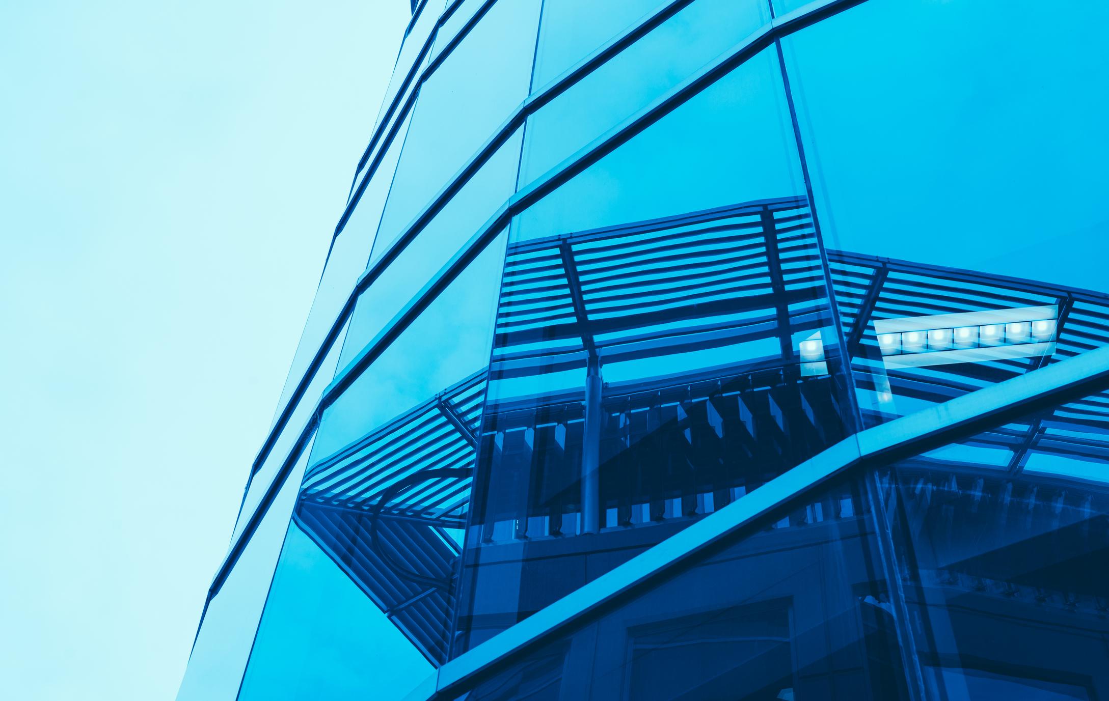 Spiegelung Häuser An einem verglasten Gebäude spiegeln sich weitere Häuser.