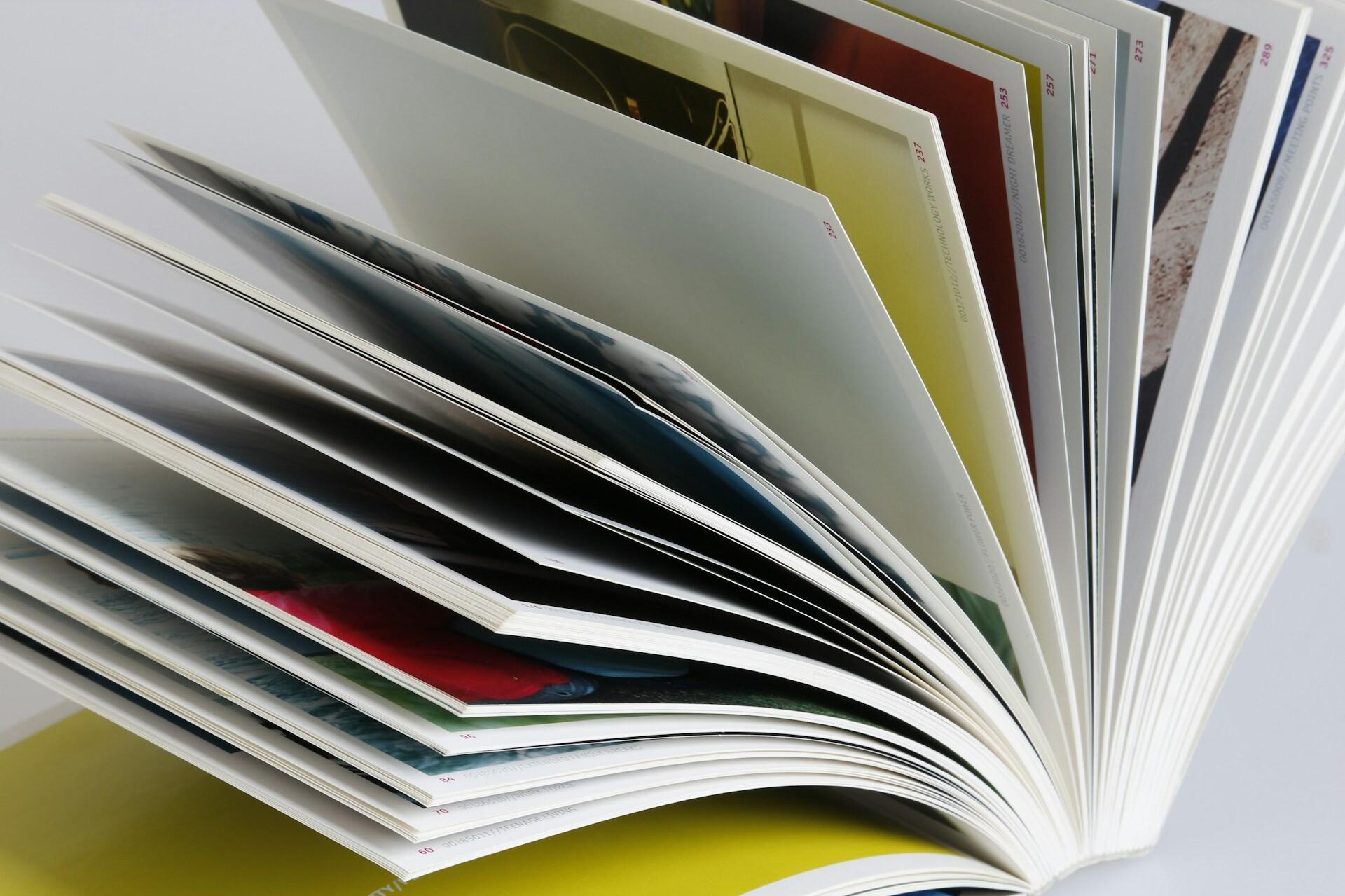 Buch Ein Buch liegt geöffnet, die Seiten sind aufgefächert.