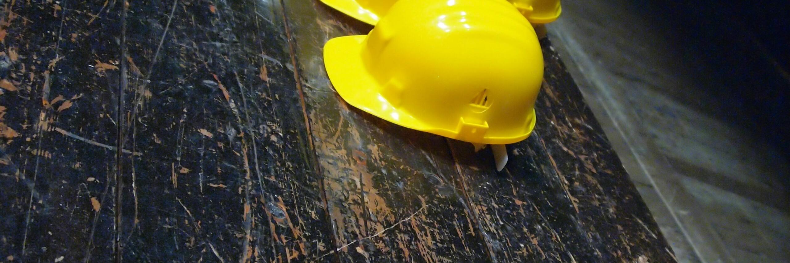 Sicherheitshelm Sicherheitshelm liegt auf einer dunklen Holz-Fläche